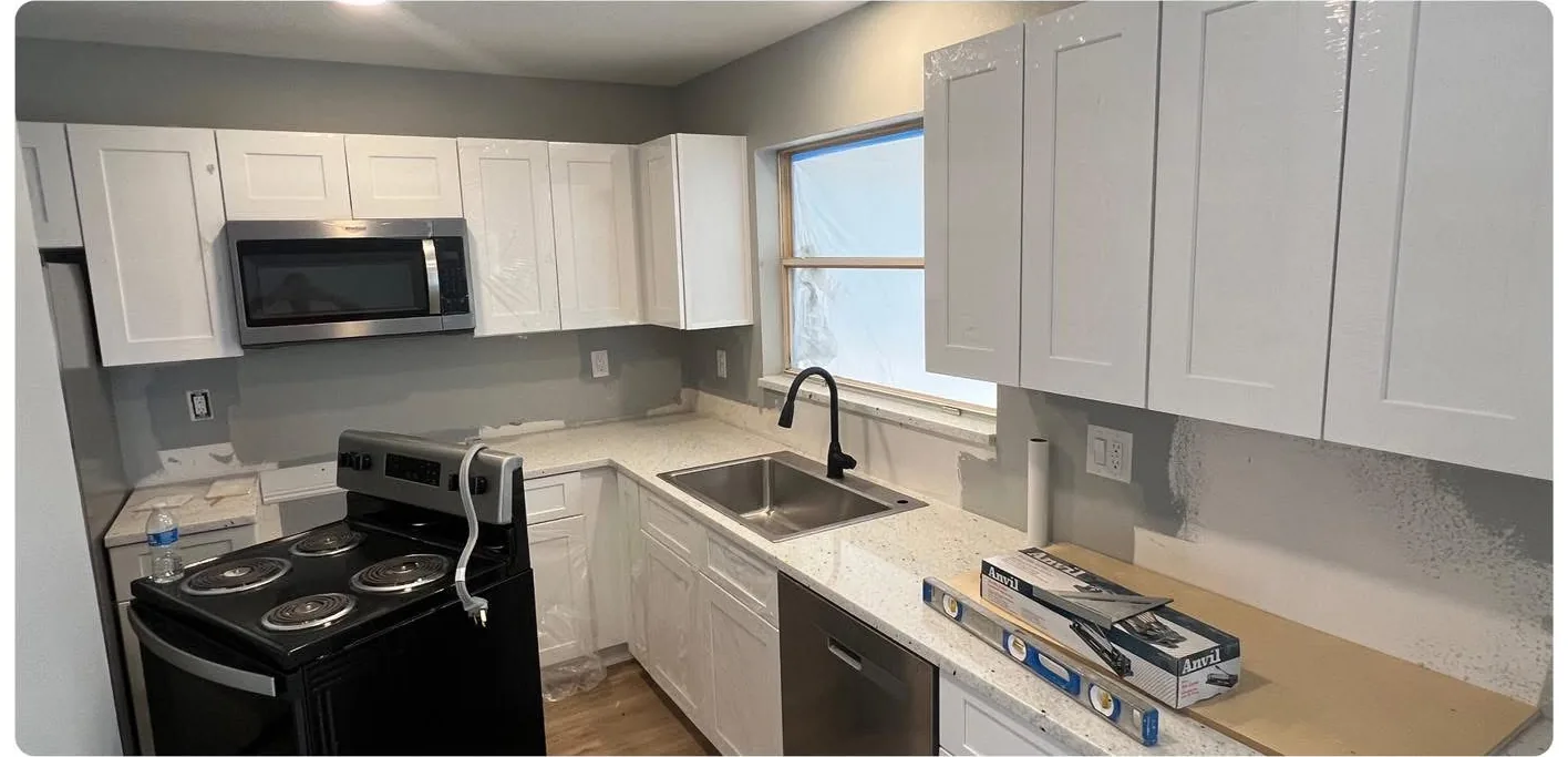 The same view before — flat dated cabinet doors and a plain wall