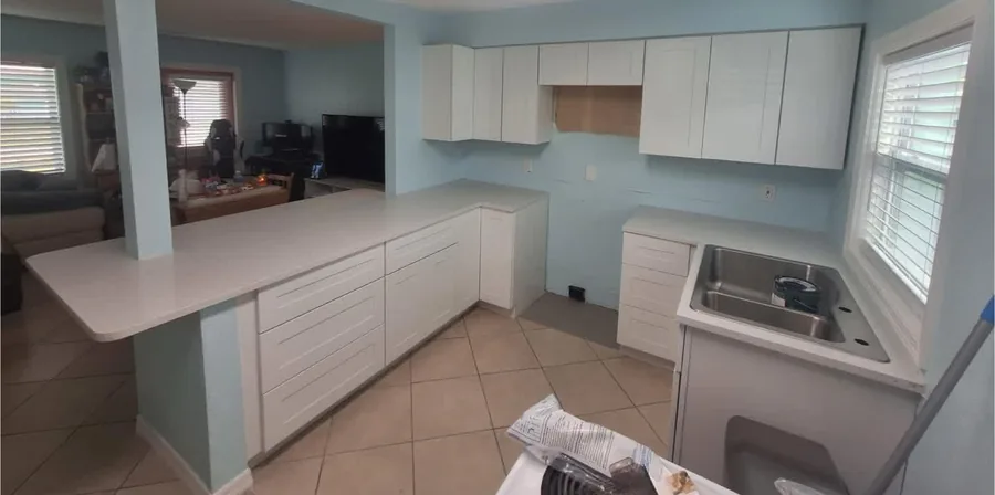 Bright White Kitchen after the work — bright white cabinetry and a light backsplash