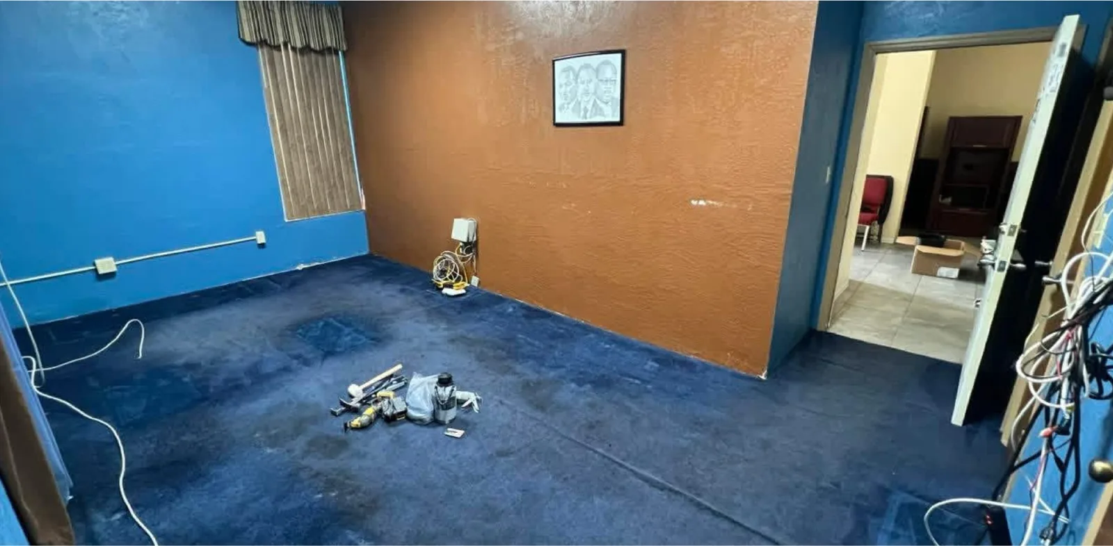 The same view before — a cluttered spare room with dated finishes